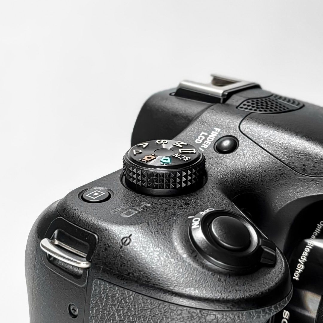 Sony Alpha a3000 Mirrorless Camera with Lens (Category: Cameras) located in Balanga. Submitted by cyrin_camera (Listing ID 1398999608, Image 2). Description: - Sony Alpha a3000 mirrorless camera with E 3.5-5.6/18-55 OSS lens. - Includes: lens hood, camera bag, strap, battery, charger, and USB adapter. - Features a mode dial for various shooting settings. - Built-in flash and display screen. - Lens has a focus ring and lens cap..