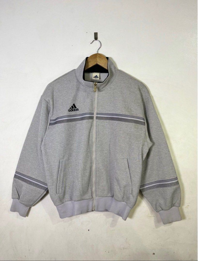 Adidas Track Jacket (Category: Coats, Jackets and Outerwear) located in Pasig City. Submitted by jijithepusa (Listing ID 1399239882, Image 1). Description: Adidas Descente Track Jacket (Gray) Length - 25.5 Width - 21 - Gray Adidas track jacket - Full zip closure - Adidas logo on chest - Iconic stripes on sleeves - Two front pockets - Ribbed hem and cuffs - High collar.