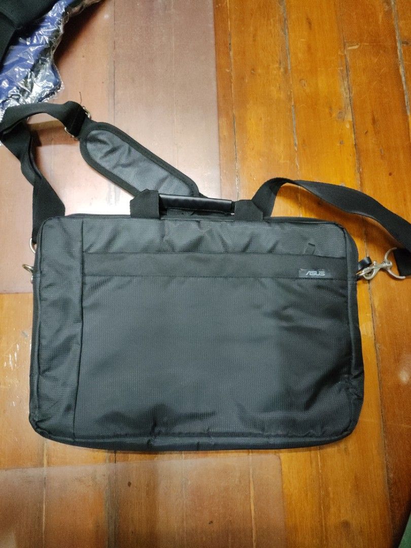Asus Laptop Bag with Shoulder Strap (Category: Laptop Bags & Sleeves) located in Manila. Submitted by seepeeaylohyer (Listing ID 1399112936, Image 1). Description: - Black laptop bag - Includes shoulder strap - Features a main compartment and side pocket - Made of durable, textured material - Metal hook for strap - Perfect for laptops and essentials.