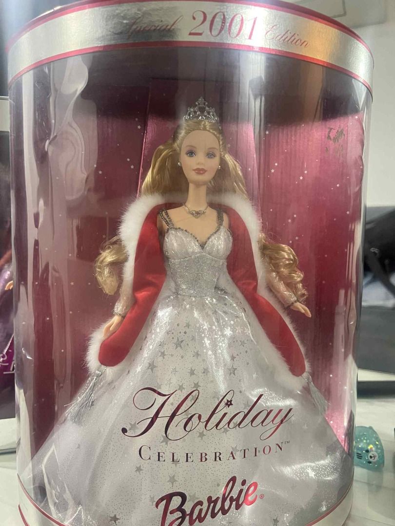 Barbie Holiday Celebration 2001 Special Edition (Category: Figurines & Statues) located in Bulacan. Submitted by ixi14 (Listing ID 1399050216, Image 2). Description: - 2001 Barbie Holiday Celebration Special Edition doll - Still in original packaging - Features: - White dress with silver star accents - Red cape with white fur trim - Tiara.