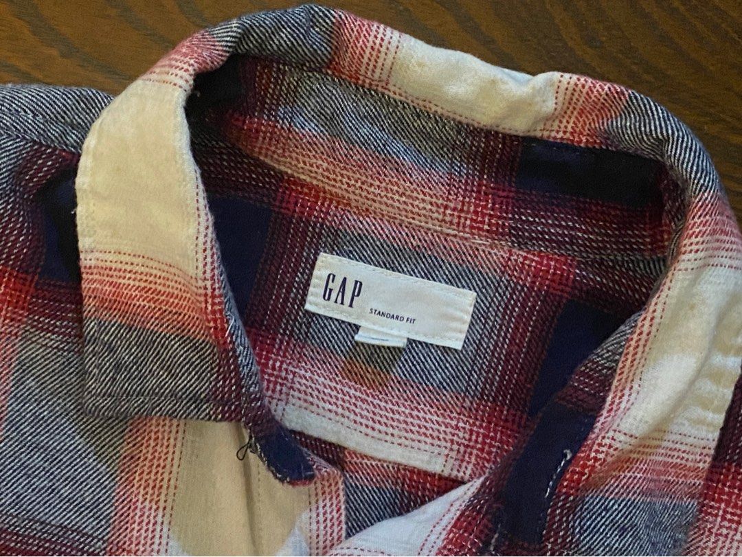 GAP Standard Fit Plaid Shirt (Category: Tshirts & Polo Shirts ) located in Angeles City. Submitted by hunymoons (Listing ID 1399159998, Image 2). Description: - GAP Standard Fit shirt - Classic plaid pattern: red, white, and navy blue - Button-down front - Two chest pockets - Long sleeves with buttoned cuffs - Soft, comfortable fabric - Perfect for casual wear - Features the GAP label on the collar.