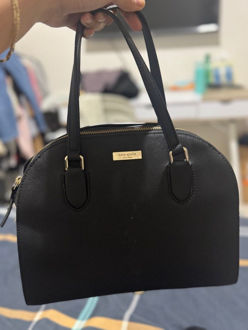 Kate Spade Black Handbag (Category: Luxury Bags & Wallets) located in Manila. Submitted by fiercestorm-45b0 (Listing ID 1399212334, Image 1). Description: - Authentic Kate Spade handbag: no Sling - Classic black color - Elegant gold-tone hardware - Secure top zipper closure - Comfortable dual top handles - Interior features signature Kate Spade fabric lining - Iconic gold Kate Spade logo on the front.