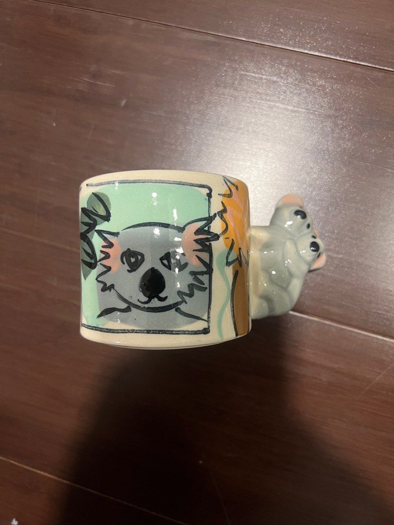 Koala Dingo Clay Australia Mug (Category: Coffee & Tea Tableware) located in Quezon City. Submitted by simp4harry (Listing ID 1399211418, Image 1). Description: - Ceramic mug with a charming koala design. - Features a unique koala figure as the handle. - Light-colored interior. - Painted exterior with koala and tree illustrations. - Ideal for coffee or tea..