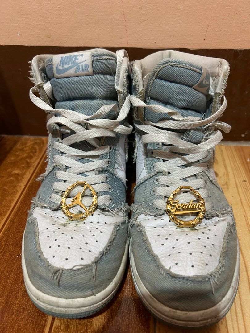 Nike Air Jordan 1 High Denim (Category: Sneakers) located in San Leonardo. Submitted by ur_chai (Listing ID 1399121026, Image 1). Description: - Air Jordan 1 High sneakers - Denim design with white and blue accents - High-top silhouette - Nike Air logo on the tongue - Gold-colored Jordan charms on laces - Unique, worn denim aesthetic Bought for 11k Issue: heavily used, no box.