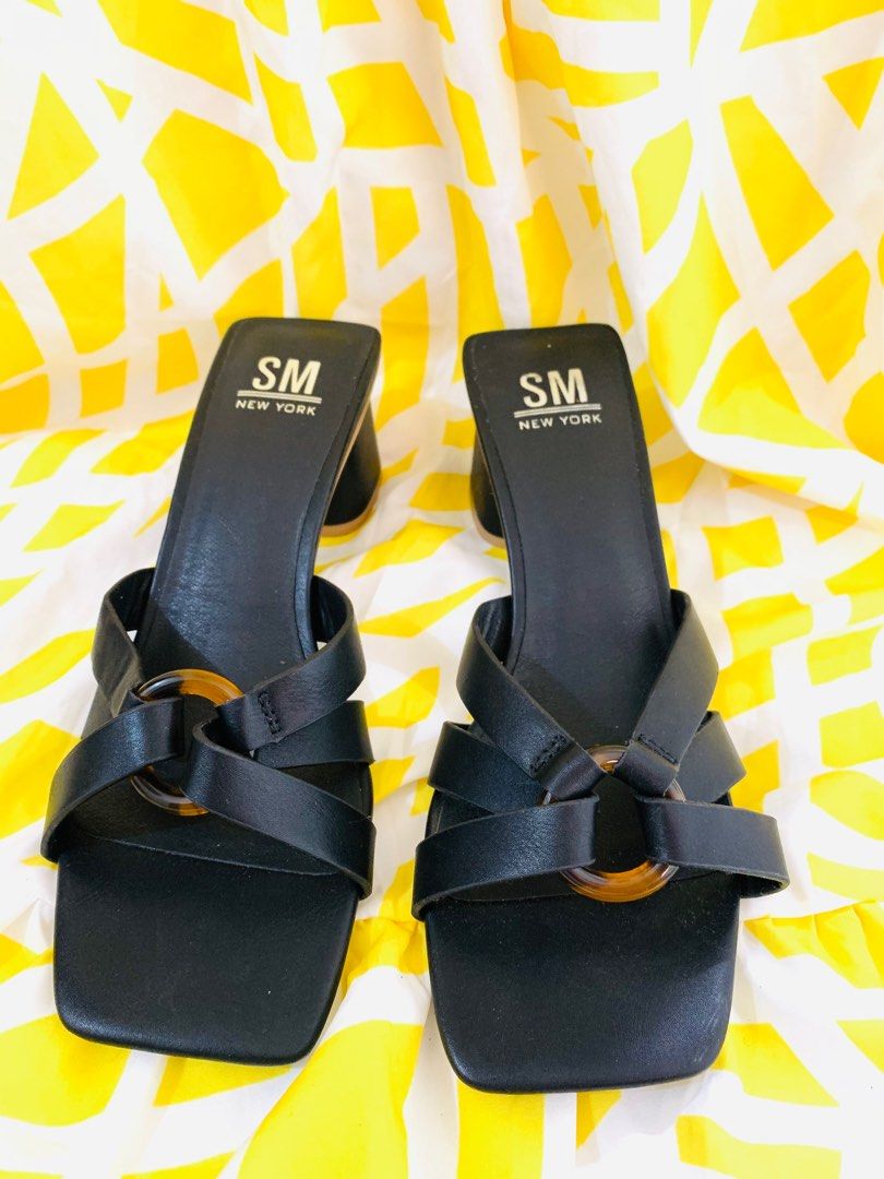SM New York Black Sandals (Category: Flats & Sandals) located in Sarrat. Submitted by alohas_wagwagan (Listing ID 1399194455, Image 1). Description: - SM New York sandals - Black color - Square toe design - Strap across foot with decorative ring - Block heel - Light brown sole - Size 8.5M.