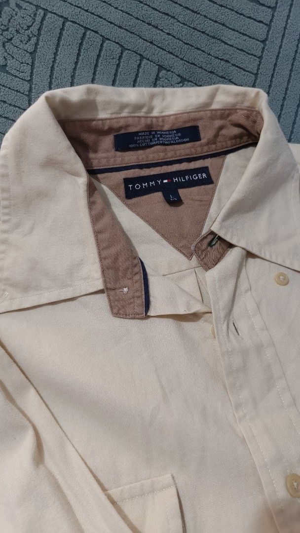 Tommy Hilfiger Long Sleeve Shirt (Category: Tshirts & Polo Shirts ) located in Rizal. Submitted by declutterwithliz (Listing ID 1399095775, Image 2). Description: - Tommy Hilfiger long sleeve shirt - Button-down style - Collared neckline - Features two chest pockets - Buttoned cuffs - Beige body with brown collar and cuff accents - Tommy Hilfiger logo on collar.