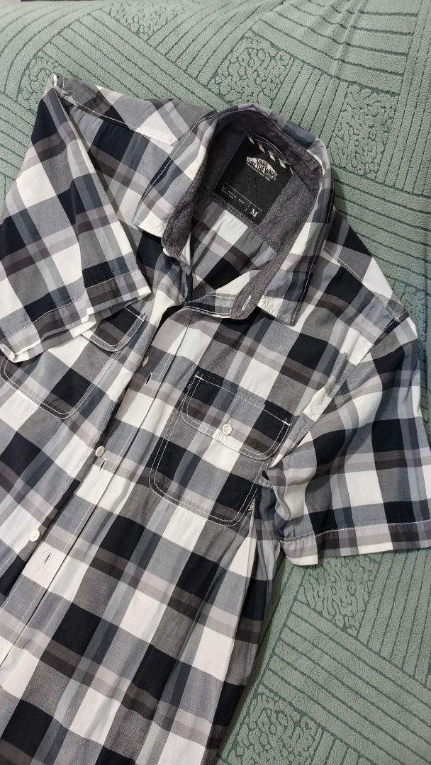 Vans Checkered Short Sleeve Shirt - Medium (Category: Tshirts & Polo Shirts ) located in Rizal. Submitted by declutterwithliz (Listing ID 1399120883, Image 1). Description: - Vans checkered short sleeve shirt - Size: Medium - Features: Button-down front, chest pocket, classic collar - Color: Black, white, and gray checkered pattern.