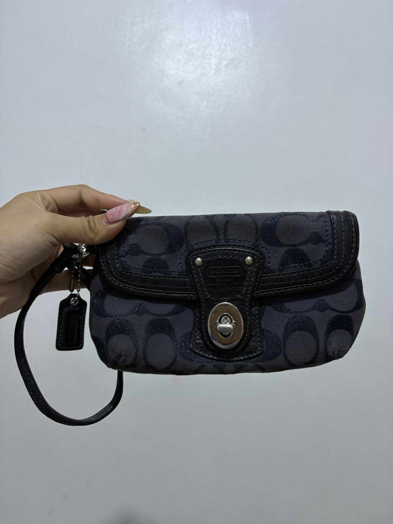Coach Wristlet (Category: Luxury Bags & Wallets) located in Batangas. Submitted by janyngaspar (Listing ID 1396079827, Image 3). Description: Coach wristlet with signature pattern. Features clasp closure, wrist strap, and Coach hang tag. Dark exterior with silver-toned hardware and Coach logo..