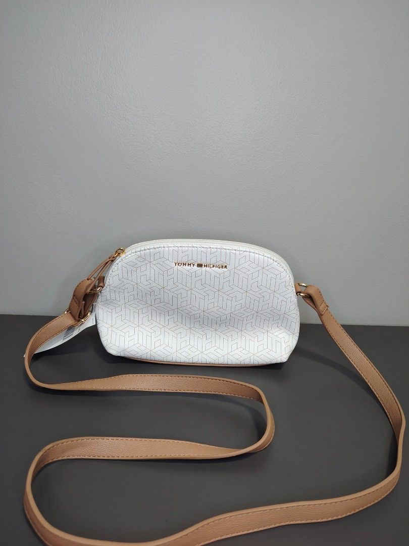 Tommy Hilfiger Crossbody Bag (Category: Luxury Bags & Wallets) located in Las Pinas. Submitted by happinoyshop (Listing ID 1396099865, Image 1). Description: 🫰Stylish and versatile Tommy Hilfiger crossbody bag 👜 Color: White with subtle TH monogram design, tan adjustable strap, gold zipper detail 📏 Perfect size for daily essentials (phone, wallet, keys, makeup, etc.) 👌 Brand new with tag ✅ Authentic Tommy Hilfiger 📍 Las Piñas City |Shipping 