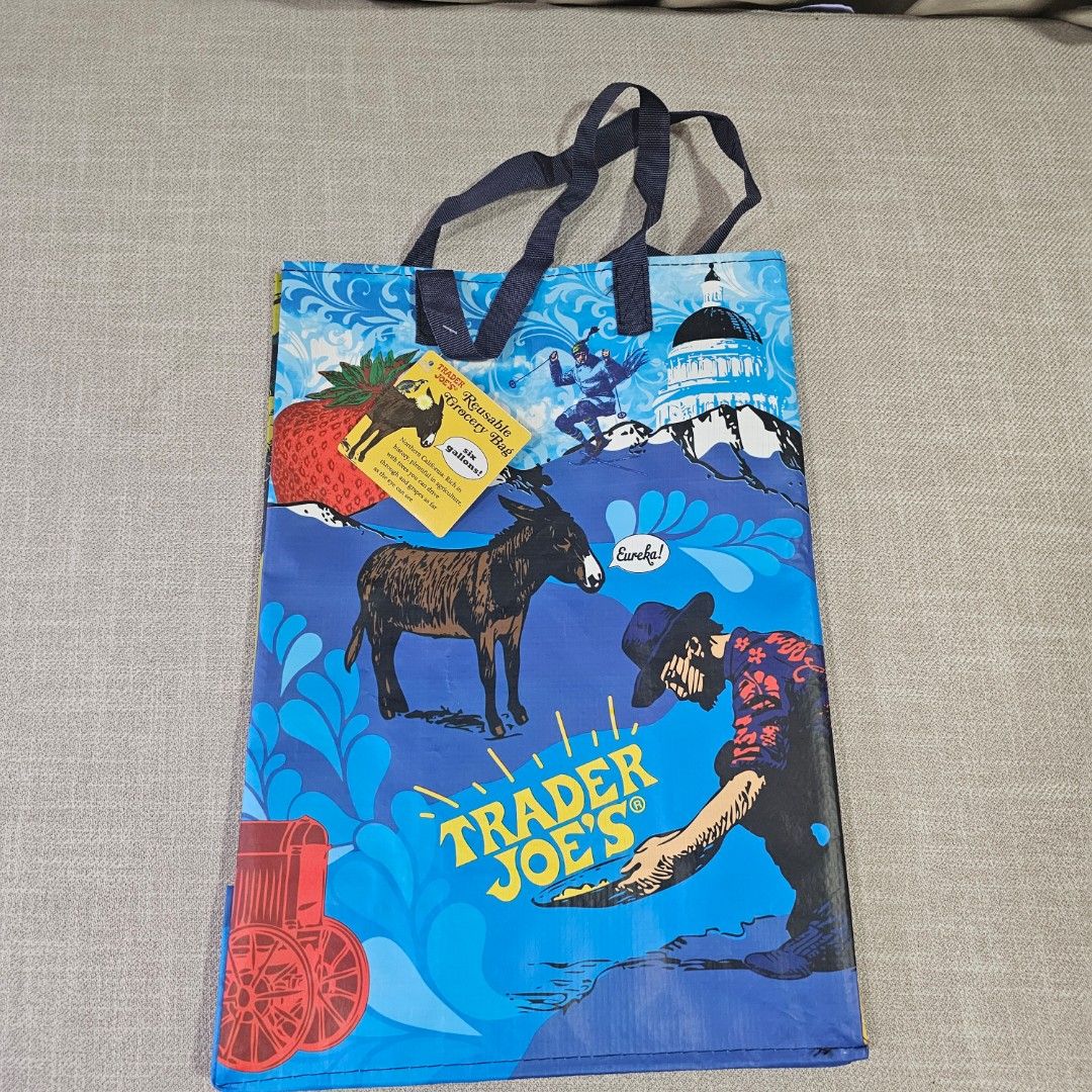 Trader Joe's Reusable Shopping Bag (Category: Tote Bags) located in Mandaluyong City. Submitted by cleanhouse.ph (Listing ID 1395988434, Image 1). Description: - Trader Joe's reusable shopping bag - Colorful blue and yellow design - Features various illustrations - Includes handles for easy carrying - Made of durable, reusable material - Perfect for groceries and everyday use.