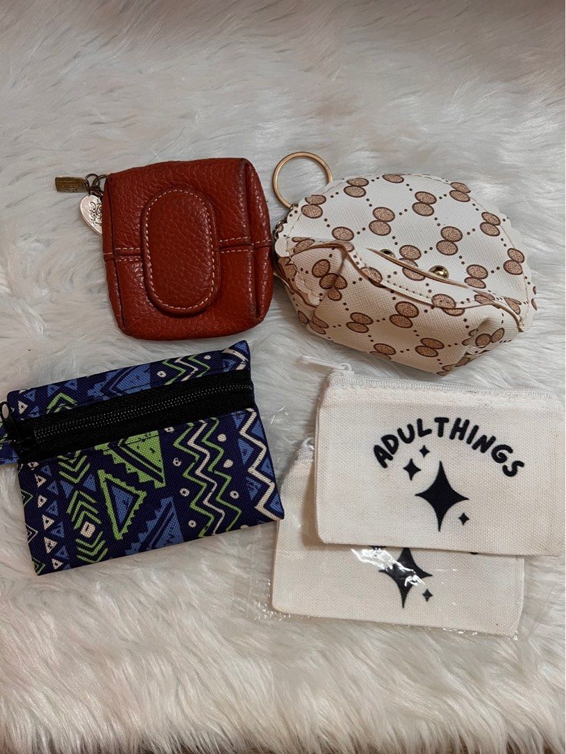 Assorted Coin Purses (Category: Purses & Pouches) located in Lubao. Submitted by mioreecollection (Listing ID 1399386440, Image 1). Description: - Brown leather coin purse with snap closure - Patterned round coin purse with keychain - Blue patterned zippered coin purse - Two small canvas pouches with "ADULTTHINGS" text.