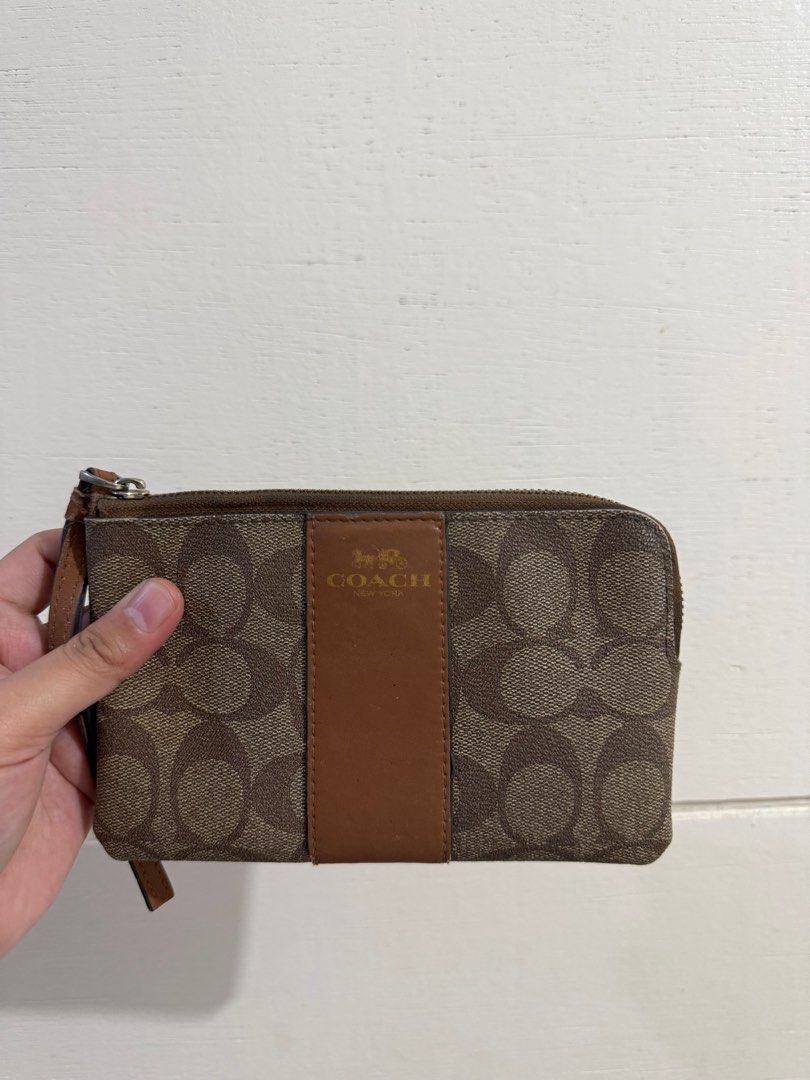 Coach Signature Wristlet (Category: Luxury Bags & Wallets) located in Angeles City. Submitted by percydlr (Listing ID 1399346675, Image 1). Description: - Coach wristlet with signature pattern - Zip closure - Wrist strap included - Multiple card slots inside - Made in Vietnam - Color: Brown with brown leather accent Minimal issue on the strap but the rest is good. Signs of usage and needs cleaning due to storage. Please manage your expectations. 