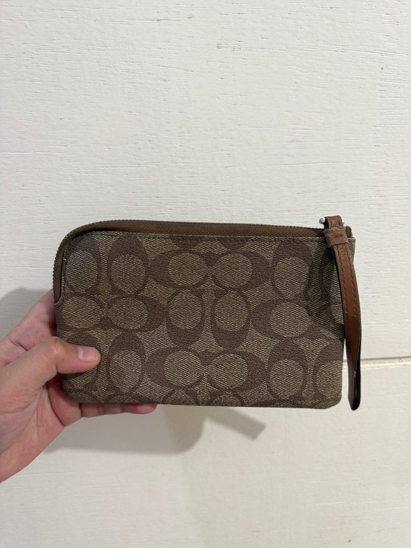 Coach Signature Wristlet (Category: Luxury Bags & Wallets) located in Angeles City. Submitted by percydlr (Listing ID 1399346675, Image 3). Description: - Coach wristlet with signature pattern - Zip closure - Wrist strap included - Multiple card slots inside - Made in Vietnam - Color: Brown with brown leather accent Minimal issue on the strap but the rest is good. Signs of usage and needs cleaning due to storage. Please manage your expectations. 