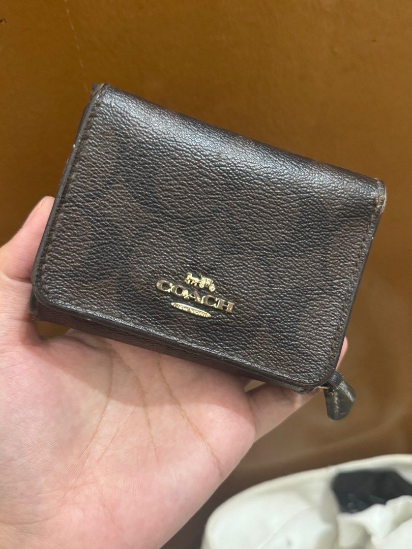 Coach Trifold Wallet (Category: Wallets & Card holders) located in Taguig. Submitted by bncdnc (Listing ID 1399334489, Image 2). Description: - Authentic Coach trifold wallet - Brown exterior with Coach logo - Black interior - Multiple card slots - ID window - Zip-around coin compartment - Snap closure - Gold-toned zipper.