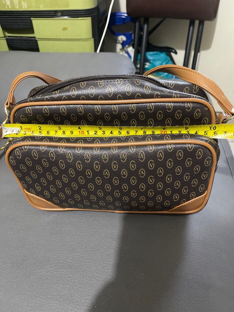 Gianni Valentino Brown Shoulder Bag (Category: Luxury Bags & Wallets) located in San Juan City. Submitted by nhelsky_c (Listing ID 1399350803, Image 1). Description: - Gianni Valentino shoulder bag - Brown and tan color scheme with 'V' pattern - long shoulder strap - Multiple compartments - Gold-toned zippers - Dark brown interior lining - Small interior pocket - Dimensions: Approximately 10 inches (length) x 8 inches (height).