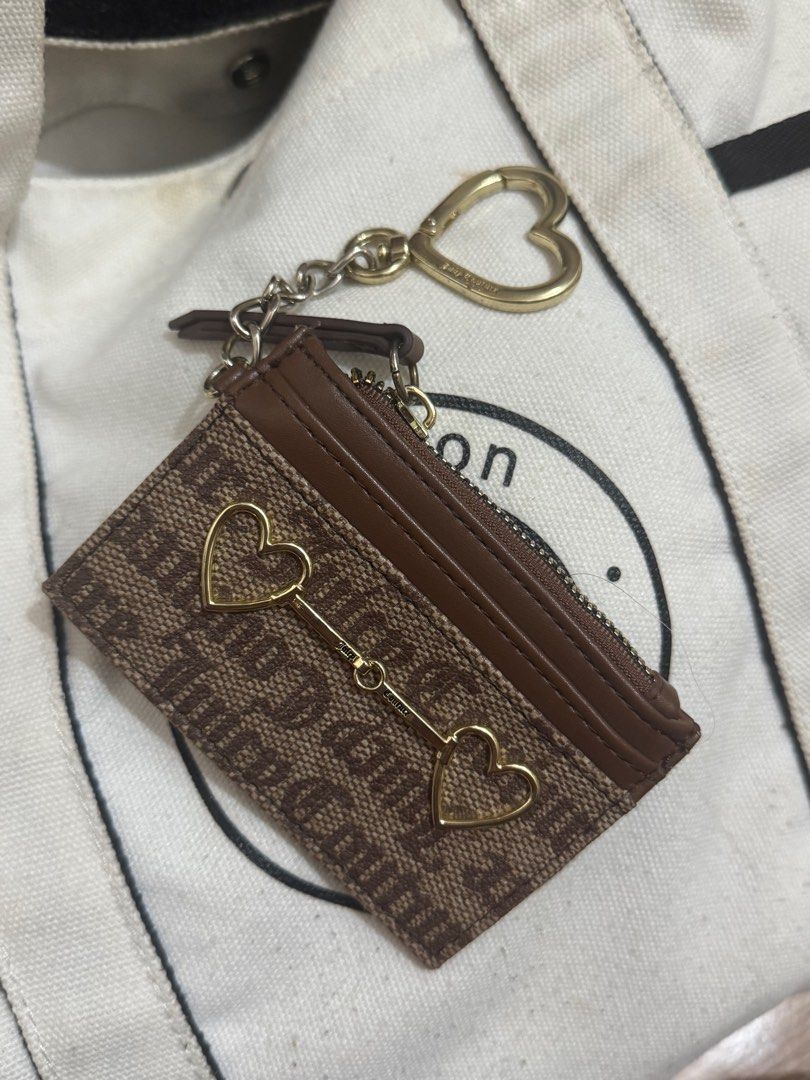 Juicy Couture Cardholder with Keychain (Category: Wallets & Card holders) located in Taguig. Submitted by bncdnc (Listing ID 1399334942, Image 2). Description: - Authentic Juicy Couture cardholder - Brown and tan design - Includes a zippered compartment - Multiple card slots for organization - Comes with a gold-toned heart-shaped keychain - Interior lining with Juicy Couture logo - Perfect for cards and small essentials.