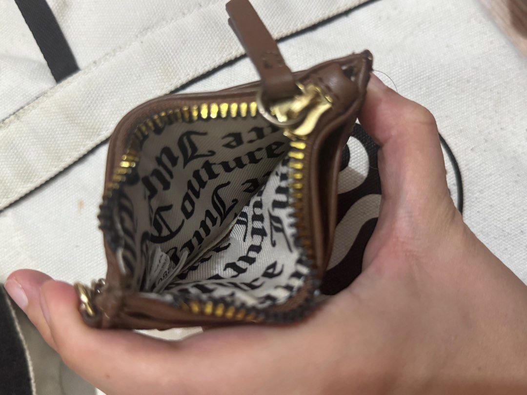 Juicy Couture Cardholder with Keychain (Category: Wallets & Card holders) located in Taguig. Submitted by bncdnc (Listing ID 1399334942, Image 3). Description: - Authentic Juicy Couture cardholder - Brown and tan design - Includes a zippered compartment - Multiple card slots for organization - Comes with a gold-toned heart-shaped keychain - Interior lining with Juicy Couture logo - Perfect for cards and small essentials.