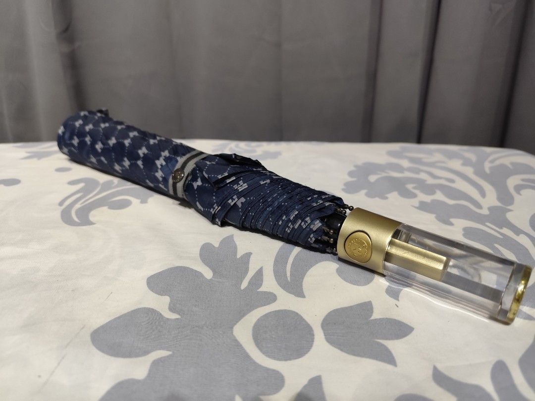 Metrocity Folding Umbrella (Category: Umbrellas) located in Santa Rosa. Submitted by ahroncatpad (Listing ID 1399431590, Image 1). Description: - Metrocity folding umbrella -automatic - Navy blue and white pattern - Gold handle with clear plastic detail - Includes Metrocity logo - Folds up for easy storage.