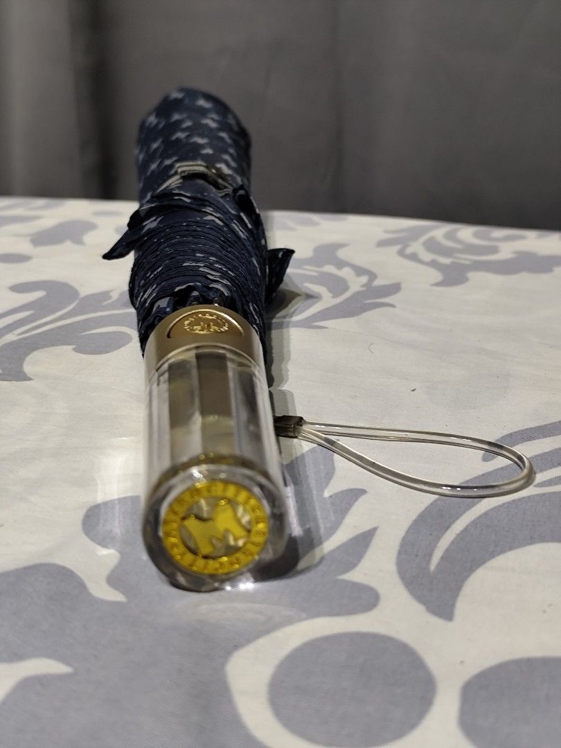 Metrocity Folding Umbrella (Category: Umbrellas) located in Santa Rosa. Submitted by ahroncatpad (Listing ID 1399431590, Image 2). Description: - Metrocity folding umbrella -automatic - Navy blue and white pattern - Gold handle with clear plastic detail - Includes Metrocity logo - Folds up for easy storage.