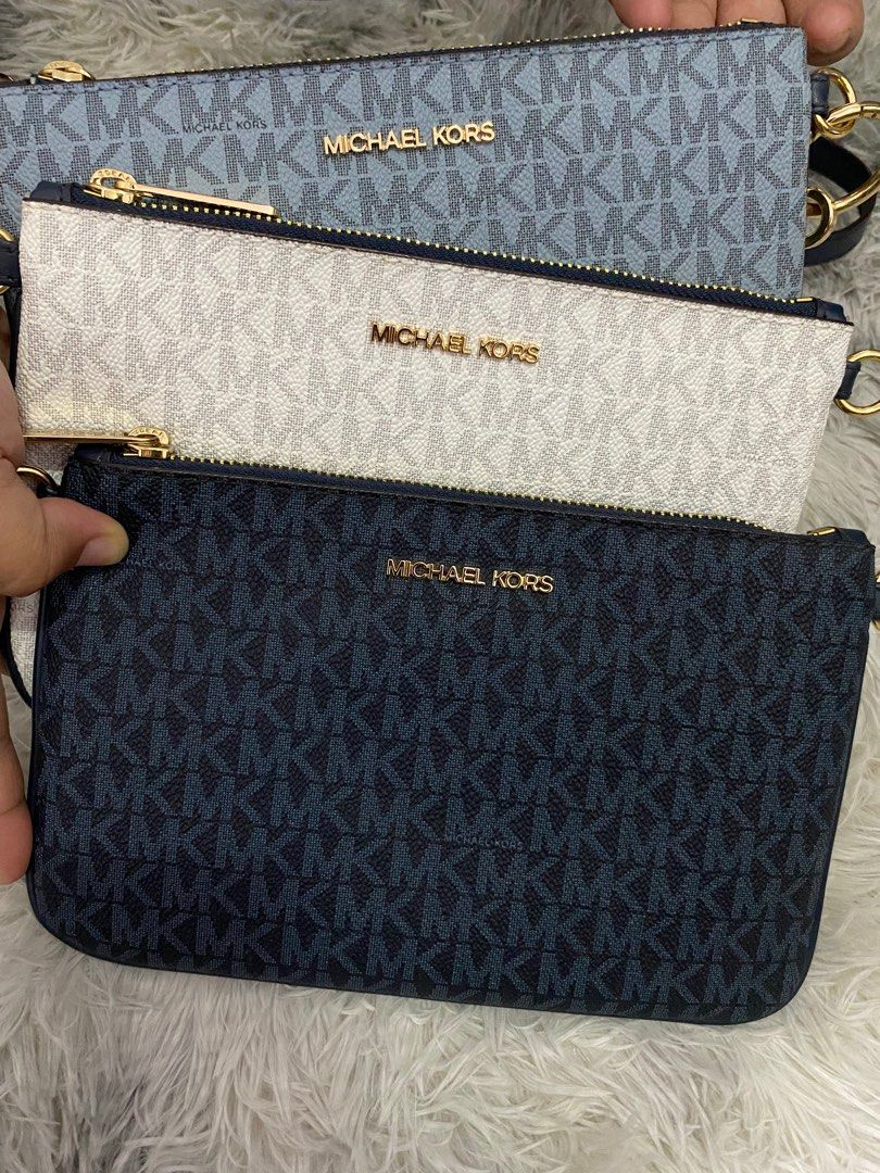 Michael Kors Clutch Bag (Category: Luxury Bags & Wallets) located in Manila. Submitted by lawin1969 (Listing ID 1399442725, Image 1). Description: - Michael Kors clutch bag - Available colors: blue, white, navy - Features the iconic MK logo - Detachable strap included - Perfect for any occasion.