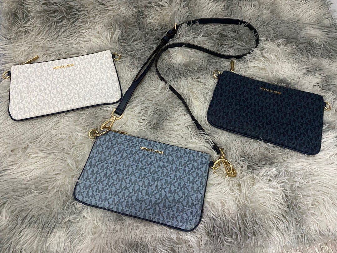 Michael Kors Clutch Bag (Category: Luxury Bags & Wallets) located in Manila. Submitted by lawin1969 (Listing ID 1399442725, Image 3). Description: - Michael Kors clutch bag - Available colors: blue, white, navy - Features the iconic MK logo - Detachable strap included - Perfect for any occasion.