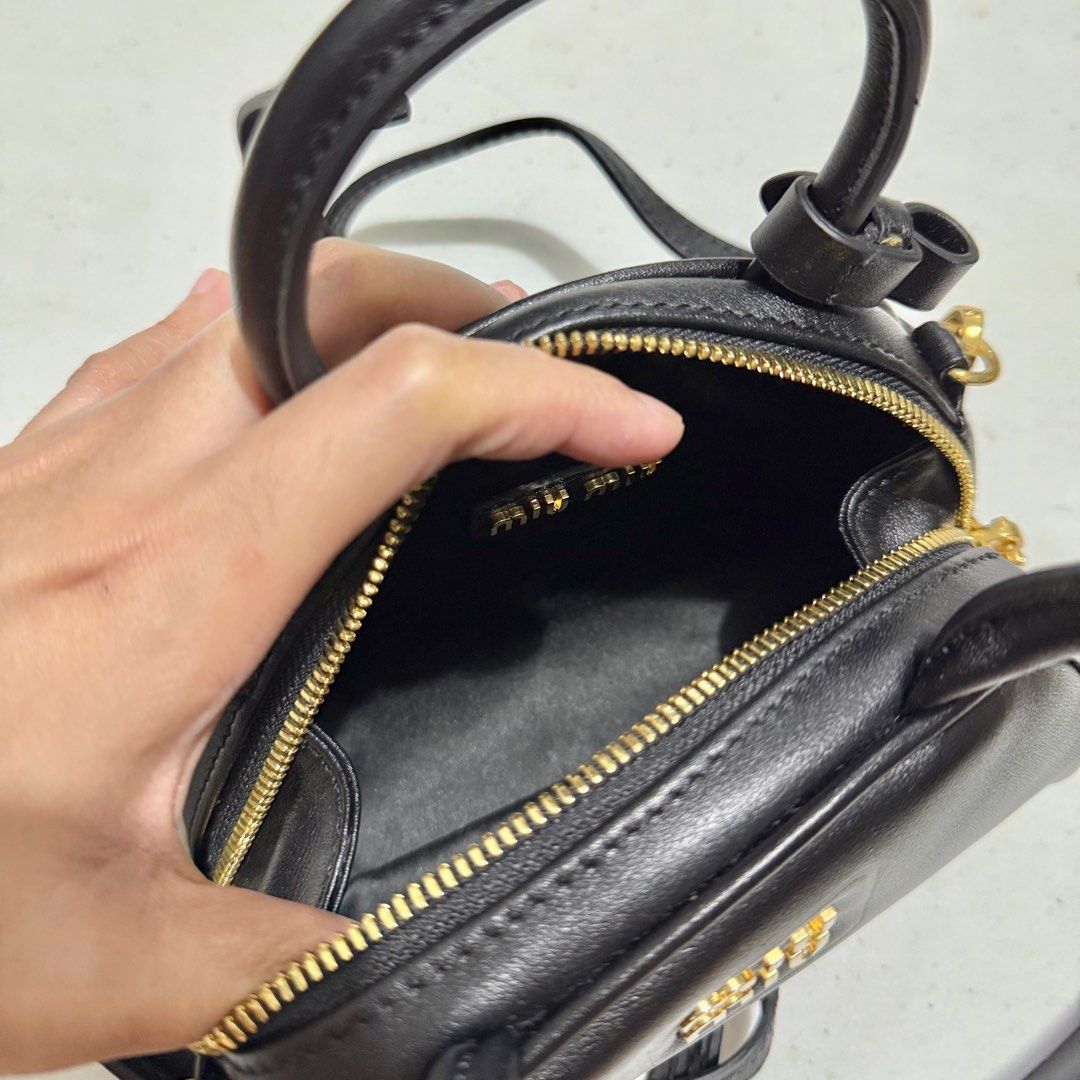 Miu Miu Mini Top Handle Shoulder Bag (Category: Luxury Bags & Wallets) located in Quezon City. Submitted by nanaskbeauty (Listing ID 1399408559, Image 2). Description: - Miu Miu mini handbag - Black color - Gold-tone hardware - Top handle and detachable shoulder strap - Compact size, perfect for essentials.
