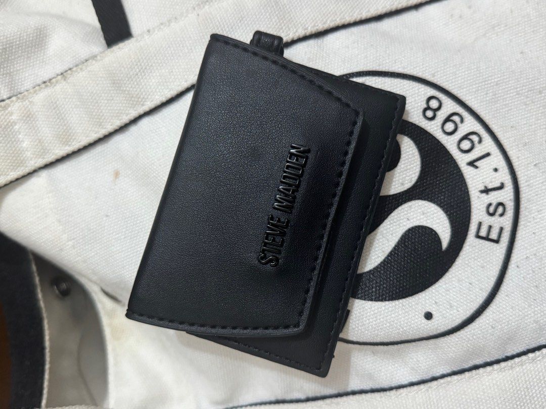 Steve Madden Black Wallet with Mirror (Category: Wallets & Card holders) located in Taguig. Submitted by bncdnc (Listing ID 1399335215, Image 1). Description: - Black Steve Madden wallet - Compact design - Includes a small mirror - Multiple compartments for cards and cash - Snap closure - Features a small loop - Steve Madden logo visible.