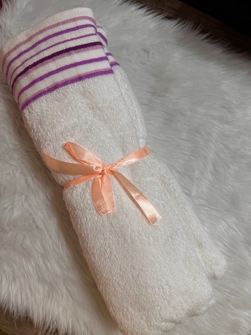 White Towel with Purple Stripes (Category: Bedding & Towels) located in Lubao. Submitted by mioreecollection (Listing ID 1399385349, Image 1). Description: - Soft white towel - Purple striped edge - Tied with a peach ribbon - Unused and clean - Ideal for personal use or as a gift - Made of absorbent material.