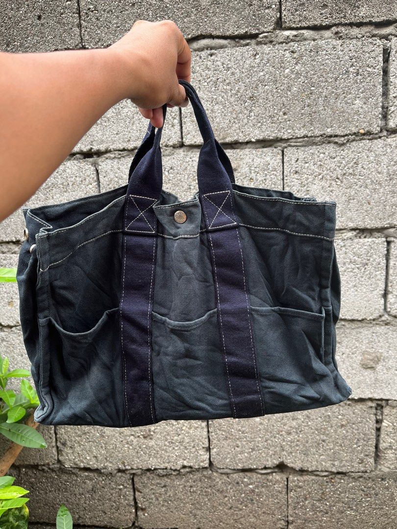 Hermes Paris Tote Bag (Category: Luxury Bags & Wallets) located in General Santos City (Dadiangas). Submitted by thiftnibadi3 (Listing ID 1399557725, Image 2). Description: - Authentic Hermes Paris tote bag - Navy blue canvas exterior - Multiple pockets - Snap closure - Sturdy handles - Navy blue stripe detail - Made in France, 100% cotton - Shows wear on corners.