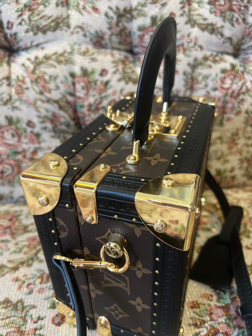 Louis Vuitton Petite Malle Handbag Reverse (Category: Luxury Bags & Wallets) located in Candelaria. Submitted by sac_du_jour (Listing ID 1399593052, Image 2). Description: - Louis Vuitton Petite Malle - Iconic monogram canvas - Black leather trim - Gold-tone hardware - Top handle and detachable shoulder strap - Structured trunk design - Secure clasp closure - Adds a touch of luxury.
