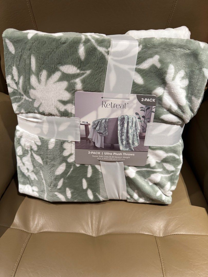 Retreat Ultra Plush Throw Blanket 2-Pack (Category: Cushions & Throws) located in Quezon City. Submitted by tinylee60 (Listing ID 1399587811, Image 1). Description: - 2-Pack of Retreat Ultra Plush Throw Blankets - Includes one blanket with a green and white floral pattern and one solid white blanket. - Made of super soft 100% polyester. - All-season weight. - Dimensions: 60" x 70" (152 cm x 177 cm) each..