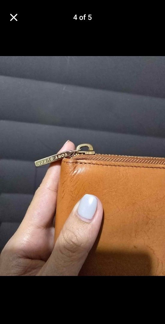 Tory Burch Zip Around Wallet (Category: Wallets & Card holders) located in Manila. Submitted by muliph (Listing ID 1399528665, Image 3). Description: - Tory Burch long wallet - Zip-around closure - Multiple card slots - Gold-tone logo emblem - Made of genuine leather - Tan color - Brand-engraved zipper.