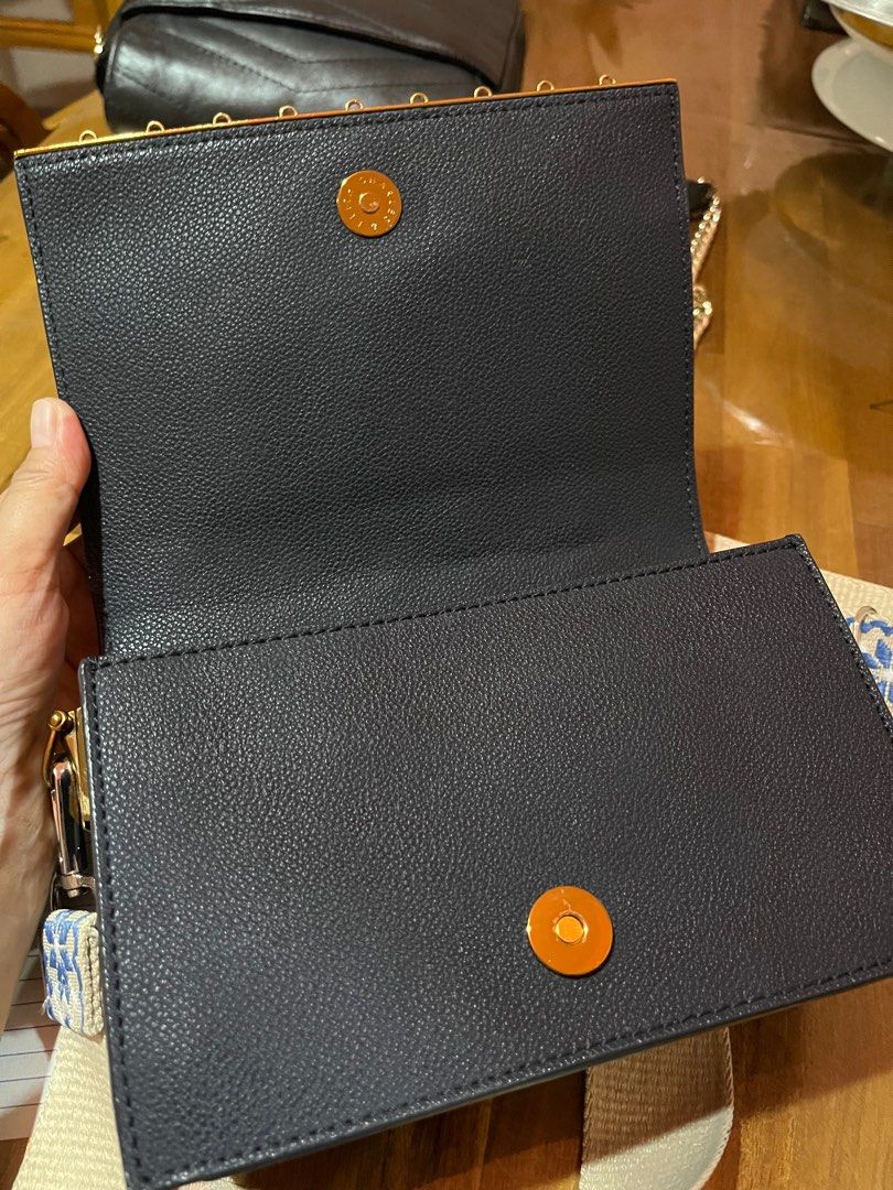 Charles & Keith Crossbody Bag (Category: Cross-body Bags) located in Angeles City. Submitted by phynes (Listing ID 1399742672, Image 3). Description: - Charles & Keith crossbody bag - Navy blue exterior - Patterned strap - Rectangular shape with flap closure - Multiple interior compartments - Dimensions: Approximately 10" wide x 7" tall - Adjustable strap - Gold-colored hardware.