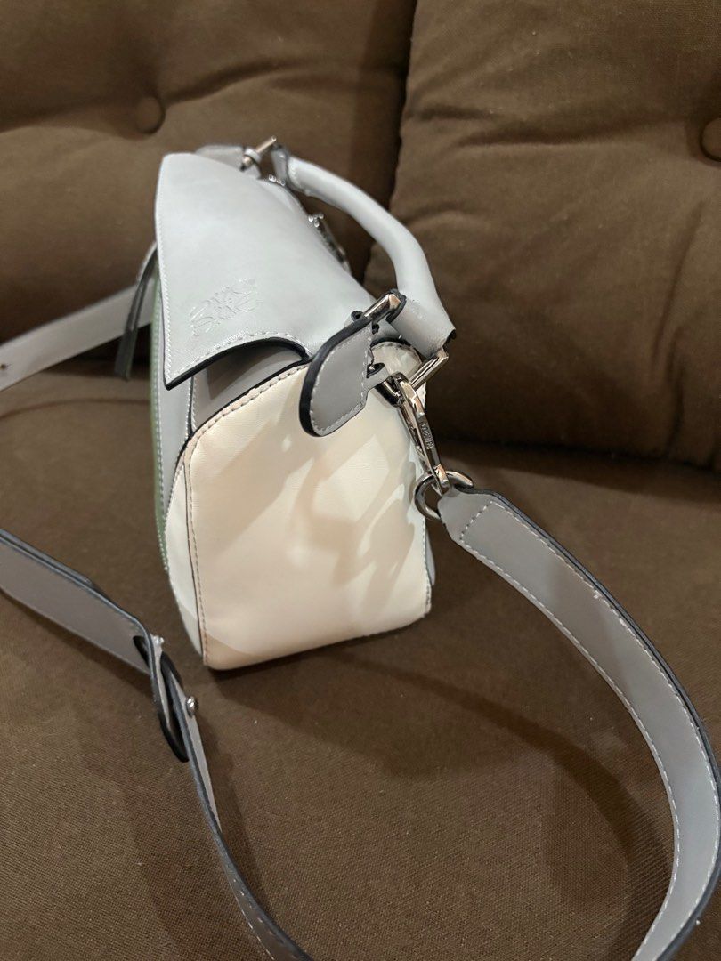 Loewe Puzzle Bag Negotiable Free SF (Category: Luxury Bags & Wallets) located in San Fernando. Submitted by srhgrc (Listing ID 1399761256, Image 3). Description: Negotiable - Loewe Puzzle Bag - Unique geometric design with grey, green, and white panels - Top handle and detachable shoulder strap - Zip closure - Fabric-lined interior with Loewe Madrid label - Metal feet on the bottom.