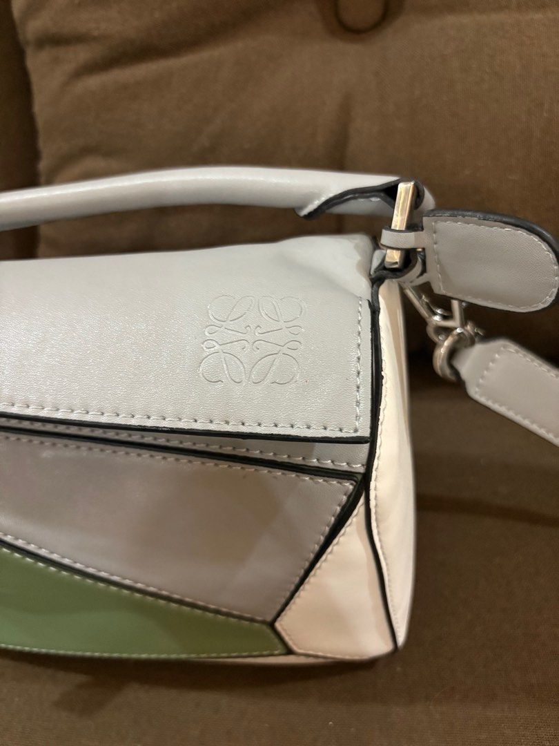 Loewe Puzzle Bag Negotiable Free SF (Category: Luxury Bags & Wallets) located in San Fernando. Submitted by srhgrc (Listing ID 1399761256, Image 2). Description: Negotiable - Loewe Puzzle Bag - Unique geometric design with grey, green, and white panels - Top handle and detachable shoulder strap - Zip closure - Fabric-lined interior with Loewe Madrid label - Metal feet on the bottom.