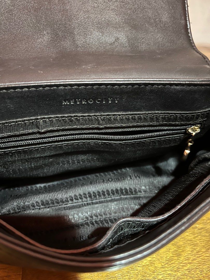 Metrocity Black Sling Bag (Category: Shoulder Bags) located in Angeles City. Submitted by phynes (Listing ID 1399743273, Image 3). Description: - Black Metrocity sling bag - and detachable leather strap - Flap closure with metal logo detail - Interior: Multiple compartments and zip pocket coded - Metal feet on the bottom - Dimensions: Approximately 23cm (length) x 17cm (height) 9/10 no major flaw .