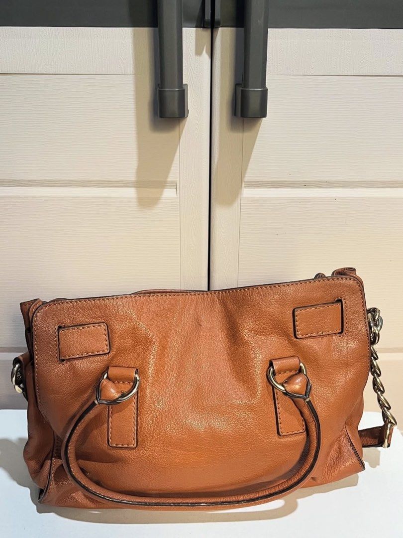 Michael Kors Hamilton Satchel Bag (Category: Luxury Bags & Wallets) located in Agoo. Submitted by grandtree-2c14 (Listing ID 1399651853, Image 2). Description: - Authentic Michael Kors Hamilton satchel bag - Brown leather exterior - Gold-tone hardware - Top handle and detachable shoulder strap - Signature MK fabric lining - Multiple interior compartments - MK logo lock closure - Stylish chain detailing.