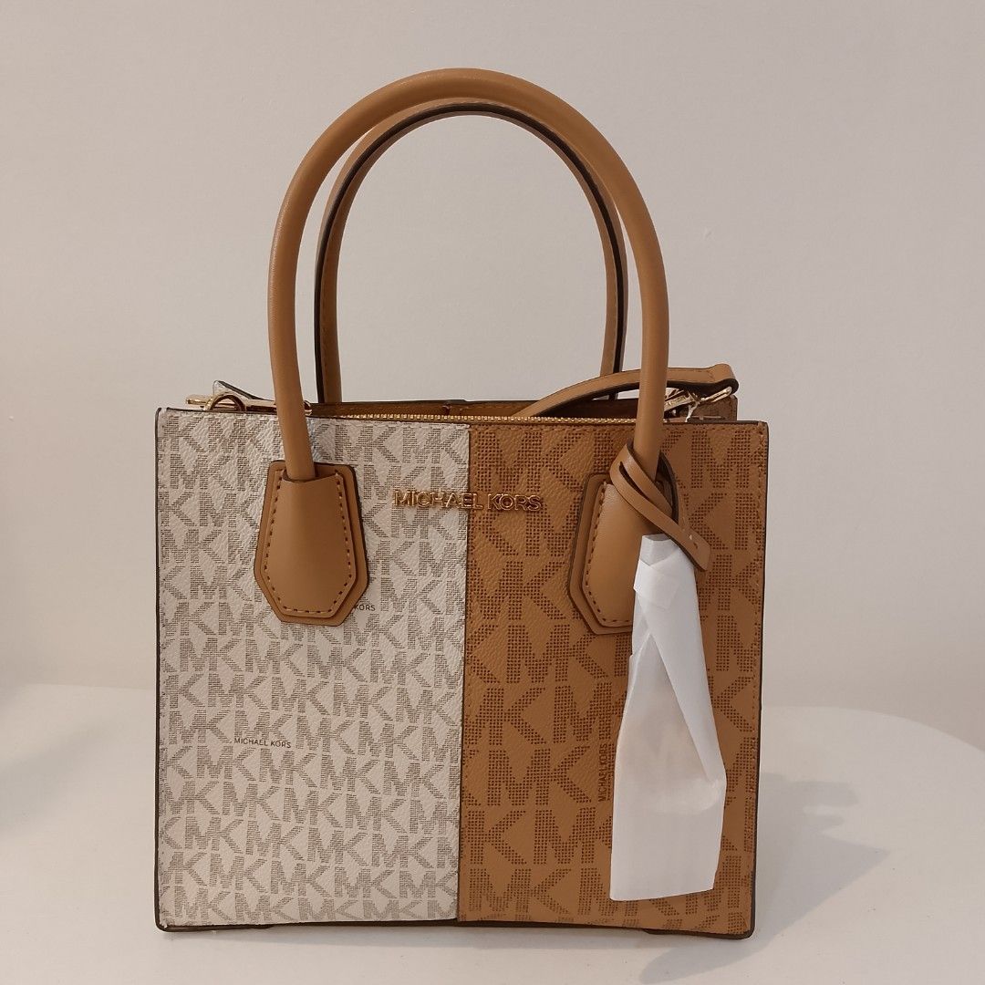 Michael Kors Mercer Gallery Small Tote Bag (Category: Luxury Bags & Wallets) located in Mandaue City. Submitted by tokyotrend03524 (Listing ID 1399711071, Image 1). Description: Michael Kors Mercer Gallery Small Tote Bag features a stylish split design with the iconic MK logo print. It has dual top handles and a detachable shoulder strap for versatile carrying options. The bag includes a top zipper closure to secure your belongings. The bag is ne