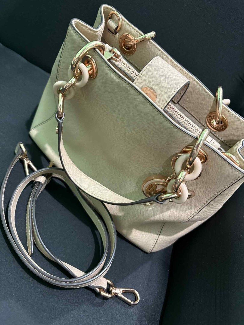 Michael Kors Satchel Handbag (Category: Luxury Bags & Wallets) located in Manila. Submitted by corryyy (Listing ID 1399827902, Image 1). Description: - Authentic Michael Kors satchel handbag - Elegant beige exterior with gold-tone hardware - Includes a detachable shoulder strap for versatile wear - Features multiple interior compartments, including a zippered pocket for secure storage - Stylish chain detail on the handles - Adorned with a signatu