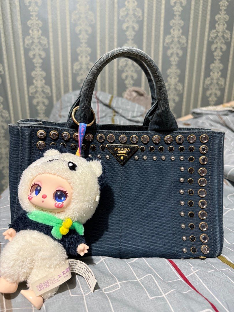 Prada Denim Studded Tote Bag (Category: Luxury Bags & Wallets) located in Quezon City. Submitted by sherraberries (Listing ID 1399652255, Image 2). Description: - Prada denim tote bag - Silver-tone stud embellishments - Dual top handles - Prada logo on front - Interior zipper - Includes a charm - Structured and stylish design.