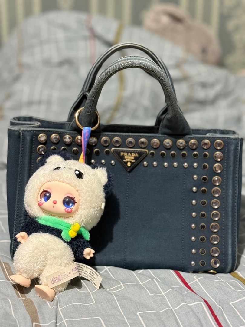 Prada Denim Studded Tote Bag (Category: Luxury Bags & Wallets) located in Quezon City. Submitted by sherraberries (Listing ID 1399652255, Image 1). Description: - Prada denim tote bag - Silver-tone stud embellishments - Dual top handles - Prada logo on front - Interior zipper - Includes a charm - Structured and stylish design.
