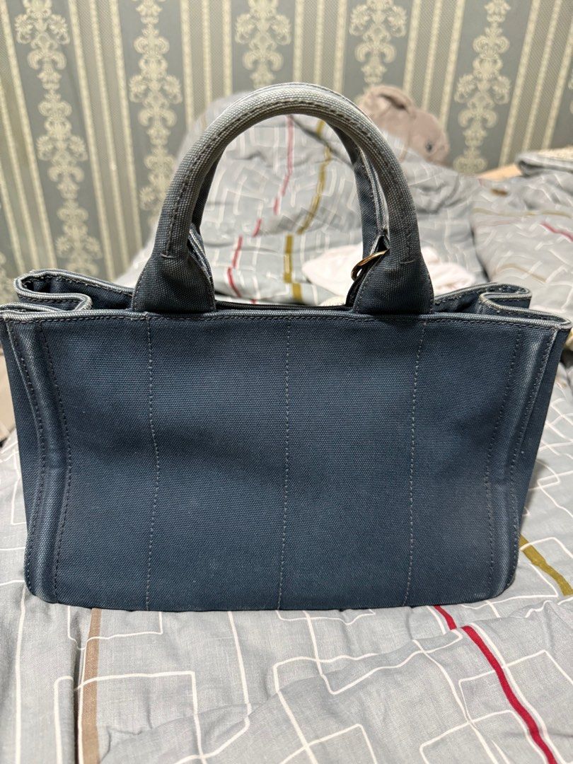 Prada Denim Studded Tote Bag (Category: Luxury Bags & Wallets) located in Quezon City. Submitted by sherraberries (Listing ID 1399652255, Image 3). Description: - Prada denim tote bag - Silver-tone stud embellishments - Dual top handles - Prada logo on front - Interior zipper - Includes a charm - Structured and stylish design.