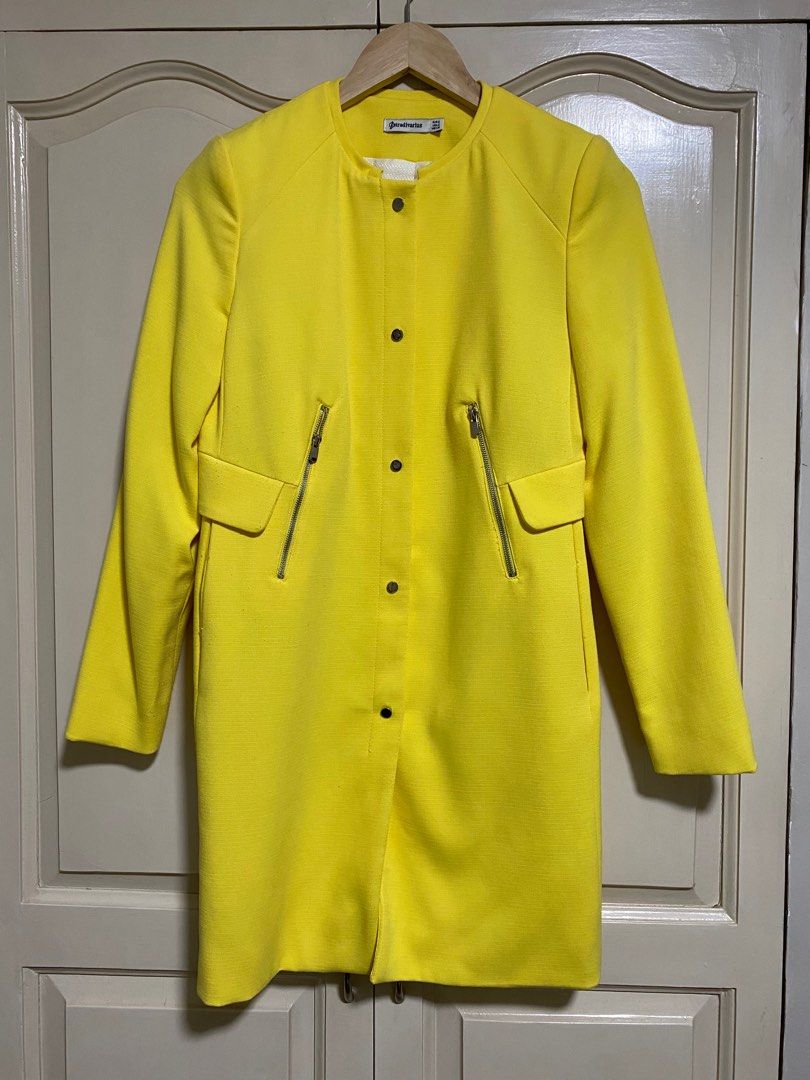 Stradivarius Yellow Coat (Category: Coats, Jackets and Outerwear) located in Mandaluyong City. Submitted by applebss (Listing ID 1399780264, Image 1). Description: - Stradivarius bright yellow coat - Size: S - Features: - Round collar - Snap button closure - Two zippered pockets - Textured fabric - Tailored fit - Clean, minimalist design - Perfect for adding a pop of color.