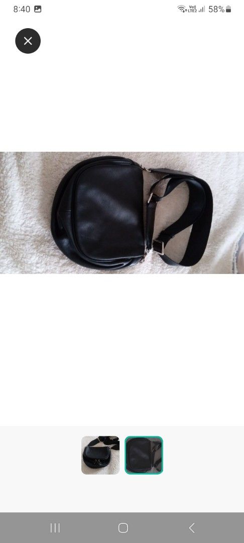 Black Leather Crossbody Bag (Category: Cross-body Bags) located in San Fernando. Submitted by rizdgr (Listing ID 1399915864, Image 2). Description: - Black leather crossbody bag - Curved design - Zippered main compartment - Adjustable strap - Silver-tone hardware - Durable strap material - Suitable for everyday use.