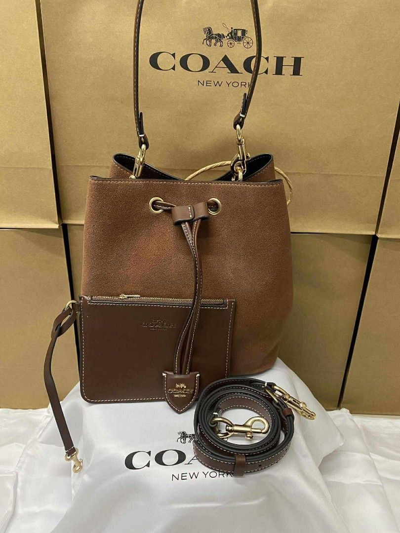 Coach Rowan Bucket (Category: Luxury Bags & Wallets) located in Batangas. Submitted by YSABELLE_MARGARETTE (Listing ID 1399987512, Image 2). Description: - Coach bucket bag - Brown suede - Detachable strap & pouch included - Drawstring closure - Gold-tone hardware - Dimensions: Approx. 22 x 21.5 cm - Includes Coach dust bag, paperbag, card, receipt & individual plastic.