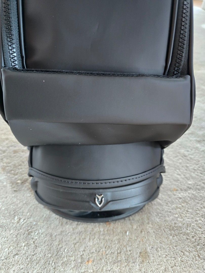 J. Lindeberg Sunday Stand Golf Bag (Category: Golf) located in Makati City. Submitted by dpadill (Listing ID 1399832214, Image 3). Description: - J. Lindeberg black golf bag - Sunday Stand bag design - Features multiple compartments - Includes a stand for easy use - Comes with a shoulder strap - Vessel logo on the base - Ideal for a quick round of golf.