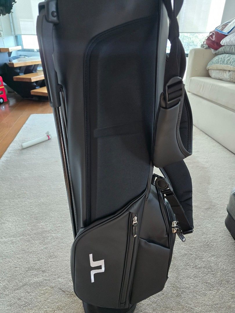 J. Lindeberg Sunday Stand Golf Bag (Category: Golf) located in Makati City. Submitted by dpadill (Listing ID 1399832214, Image 2). Description: - J. Lindeberg black golf bag - Sunday Stand bag design - Features multiple compartments - Includes a stand for easy use - Comes with a shoulder strap - Vessel logo on the base - Ideal for a quick round of golf.