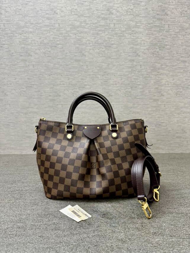 Louis Vuitton Damier Ebene Siena❗️❗️❗️ (Category: Luxury Bags & Wallets) located in Marikina City. Submitted by barelyshop (Listing ID 1399961965, Image 1). Description: PRODUCT: Louis Vuitton Damier Ebene Siena MATERIAL: Damier Ebene canvas with leather trim. FEATURES: Double rolled leather handles and a detachable, adjustable shoulder strap or crossbody wear. The bag has a Gold-toned hardware, Red textile lining with three internal pockets and 