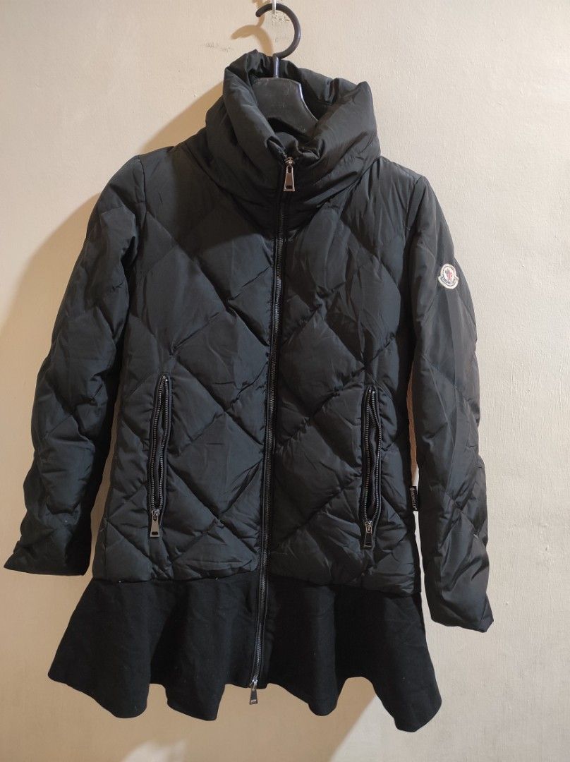 Moncler Black Puffer Jacket (Category: Coats, Jackets and Outerwear) located in Manila. Submitted by luxxxxxxxx.x (Listing ID 1399995639, Image 1). Description: Black Moncler puffer jacket. Features a quilted design, two zipped pockets, and a high collar. The jacket has the Moncler logo on the sleeve and inside the jacket. The zipper has the Moncler logo on the pull. The jacket has a unique design with a flared bottom. The jacket has a tag with w