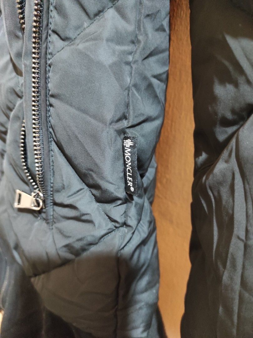 Moncler Black Puffer Jacket (Category: Coats, Jackets and Outerwear) located in Manila. Submitted by luxxxxxxxx.x (Listing ID 1399995639, Image 2). Description: Black Moncler puffer jacket. Features a quilted design, two zipped pockets, and a high collar. The jacket has the Moncler logo on the sleeve and inside the jacket. The zipper has the Moncler logo on the pull. The jacket has a unique design with a flared bottom. The jacket has a tag with w